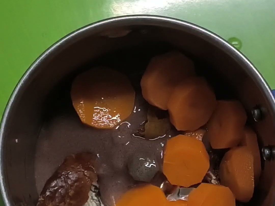 Ragi, dates and steamed carrot baby food in a small steel bowl