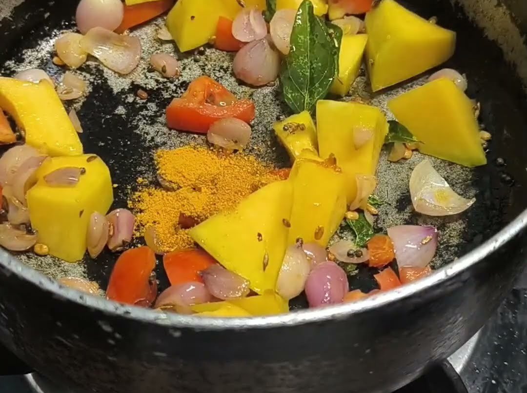 Yellow pumpkin, shallots and carrot cooking in a pan with spices
